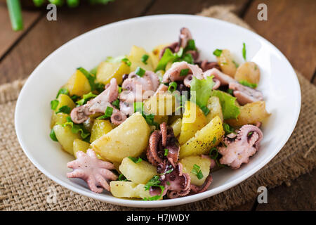 Potato salad with pickled octopus and green onions. Stock Photo