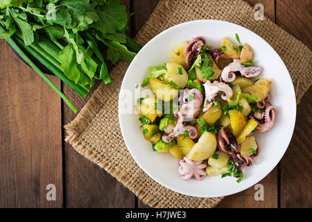 Potato salad with pickled octopus and green onions. Top view Stock Photo