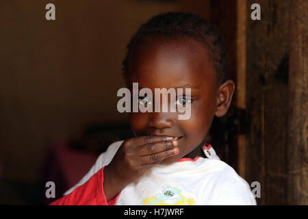 Picture taken in Kibera Slum, Nairobi, largest slum district in Kenya. Girl is standing at the door of her house. Stock Photo