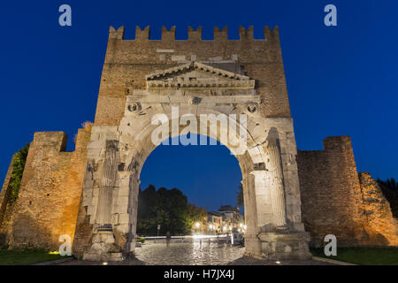 Arch of Augustus at night in Rimini, Italy. Ancient romanesque gate of the city - historical landmark, the most ancient roman ar Stock Photo