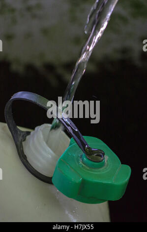 a plastic tank ist filling up from tap with fresh running source water Stock Photo