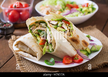 Fresh tortilla wraps with chicken and fresh vegetables on plate Stock Photo