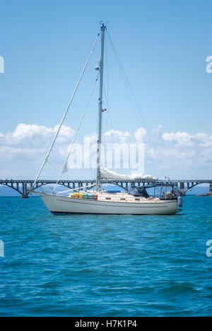 View of a sail boat ancored at Samana Bay and Los Puentes bridge at the background, Samana, Dominican Republic. Stock Photo