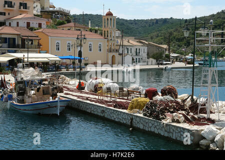 Lefkada, GREECE, May 11, 2013: Landscape with church, mooring and fishing-boat in port of Vathi on the small Meganisi island. Stock Photo