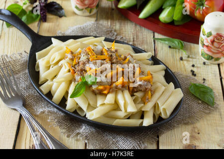 Pasta with minced meat in a frying pan on a table in a rustic style. Stock Photo