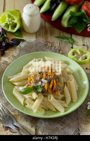 Pasta with minced meat in a frying pan on a table in a rustic style. Stock Photo