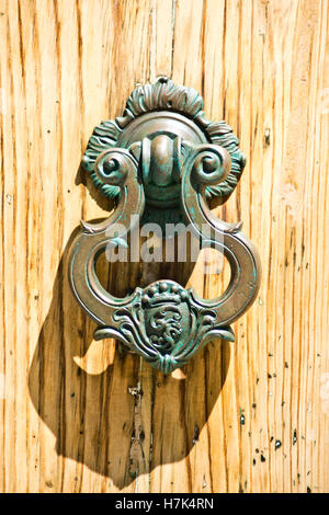 Wrought iron knocker craftsmanship of ancient historical building in the wooden door Stock Photo