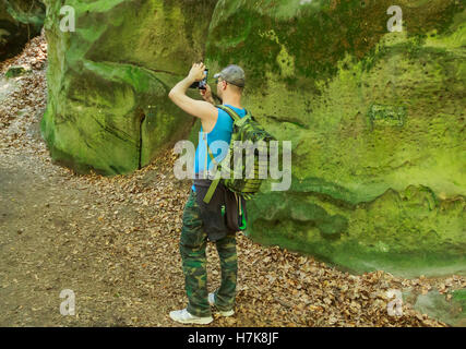 photographing man standing in nature with rocks Stock Photo