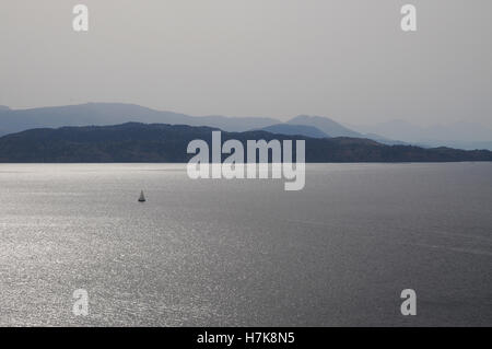atmospheric view of boats on the mediterranean sea at dusk between Greece and Albania Stock Photo