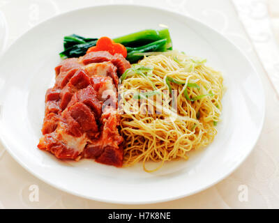 Traditional Chinese cruisine: BBQ pork noodle on white dish Stock Photo