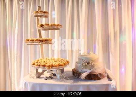 wedding cake with flowers and ribbon log stand - stand of cupcakes Stock Photo