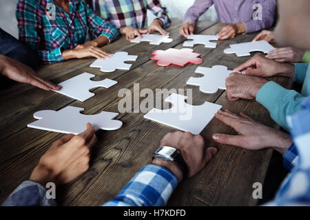 People assembling puzzle, teamwork meeting concept Stock Photo