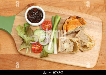 Handmade pork pie and salad on wooden chopping boards Stock Photo