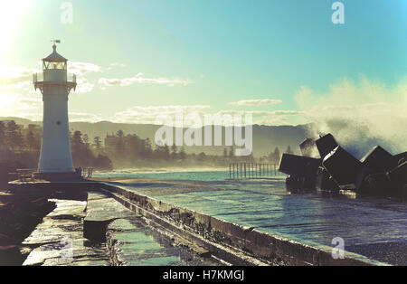 Big waves breaking over Wollongong harbor breakwall and lighthouse, Wollongong, New South Wales, Australia Stock Photo