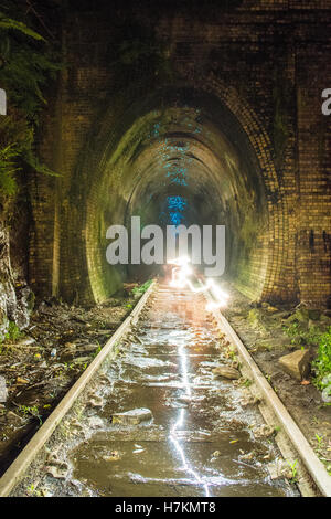 Helensburgh, Australia - 4th November 2016: Helensburgh tunnel near the old Helensburgh train station. This tunnel built between 1884 and 1886 is said to be haunted by the coal miner Robert Hales who passed away on the 13th of June 1895 after being struck by a passing steam train. Some say his ghost can be seen running from the darkness as trying to flee potential trains. - Helensburgh, New South Wales, Australia Stock Photo