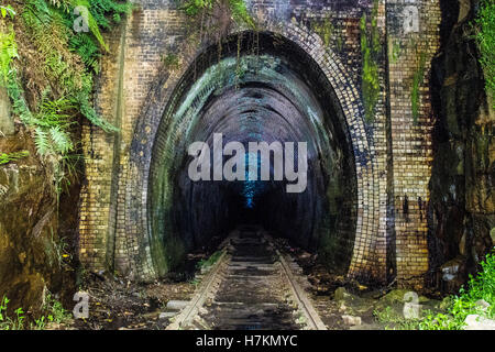 Helensburgh, Australia - 4th November 2016: Helensburgh tunnel near the old Helensburgh train station. This tunnel built between 1884 and 1886 is said to be haunted by the coal miner Robert Hales who passed away on the 13th of June 1895 after being struck by a passing steam train. Some say his ghost can be seen running from the darkness as trying to flee potential trains. - Helensburgh, New South Wales, Australia Stock Photo