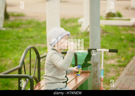 fashionable boy blowing bubbles in a city park Stock Photo