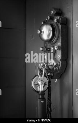 Old antique telephone hanging on wall. Vintage technology. Classic communication equipment. Stock Photo