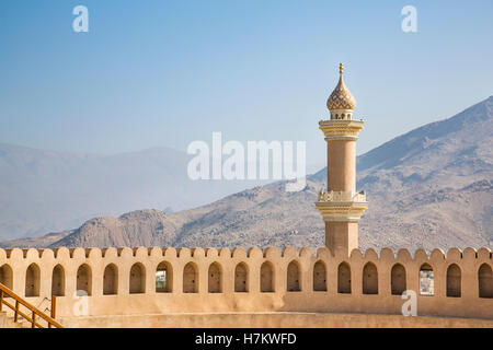 Minaret behinf a wall of a fort in Nizwa, Oman Stock Photo