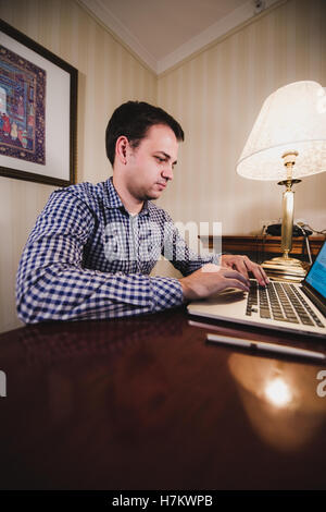 Young happy man talking on the phone at his workplace in office Stock Photo