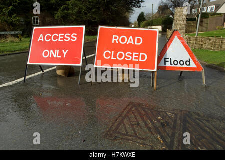 Flood and road closure signs on a flooded entry to a country road Stock Photo