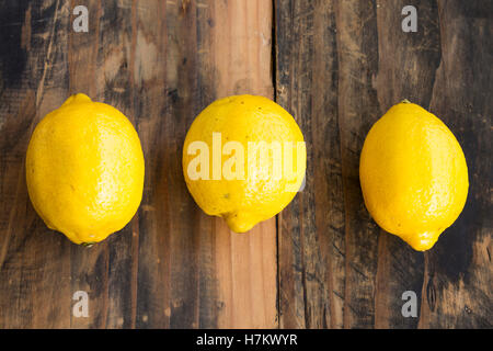 Three Lemons on Rustic Wooden Background. Stock Photo