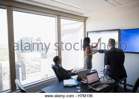 Business people meeting at large monitor in urban conference room
