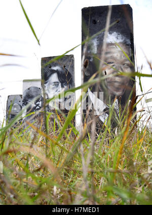 Portraits of famous personalities such as Mother Theresa (r-l), Nelson Mandela, Aung San Suu Kyi, Mahatma Gandhi and the Dalai Lama can be seen on concrete parts of the Berlin wall in Teltow, Germany, 07 Novmeber 2016. The painted sections of the wall are for sale. On 09 November, 27 years ago, the wall fell in Berlin. Photo: RALF HIRSCHBERGER/dpa Stock Photo