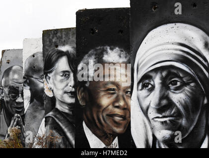 Portraits of famous personalities such as Mother Theresa (r-l), Nelson Mandela, Aung San Suu Kyi, Mahatma Gandhi and the Dalai Lama can be seen on concrete parts of the Berlin wall in Teltow, Germany, 07 Novmeber 2016. The painted sections of the wall are for sale. On 09 November, 27 years ago, the wall fell in Berlin. Photo: RALF HIRSCHBERGER/dpa Stock Photo