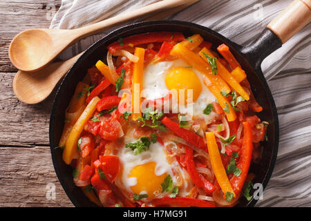 Basque breakfast: fried eggs with peppers in a pan close-up. Horizontal view from above Stock Photo