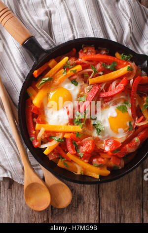 Basque breakfast: fried eggs with peppers in a pan close-up. vertical view from above Stock Photo