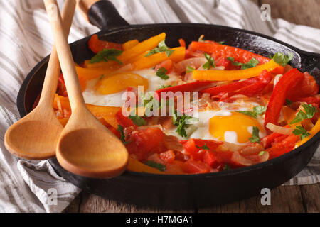 Basque breakfast: fried eggs with peppers in a pan close-up. horizontal Stock Photo