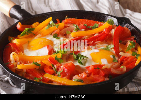 A delicious breakfast: fried eggs with peppers in a pan close-up. horizontal Stock Photo