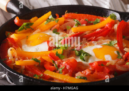 piperrada: peppers with fried eggs on the frying pan macro. horizontal Stock Photo