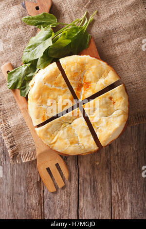 Freshly baked Greek pie with spinach on the table  vertical view from above Stock Photo
