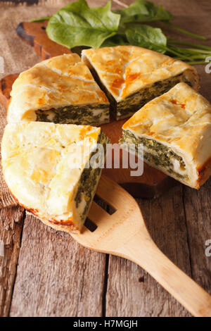 Tasty sliced Greek spanakopita pie close-up on the table. Vertical Stock Photo