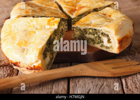 Tasty sliced Greek pie with spinach and cheese close-up on the table. horizontal Stock Photo