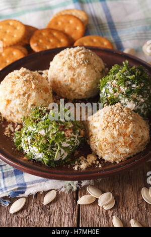 Curd cheese balls with crackers, herbs and pumpkin seeds macro on a plate. Vertical Stock Photo
