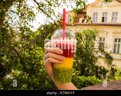 Cherry smoothie in a big glass cup with two straws in woman's hands,  isolated on white background. Lady with a drink Stock Photo - Alamy