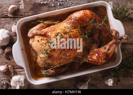 Baked Chicken with forty cloves of garlic and ingredients close-up on the table. horizontal view from above Stock Photo