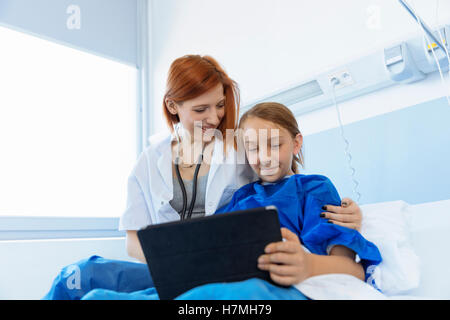 Doctor showing digital tablet to a girl patient Stock Photo