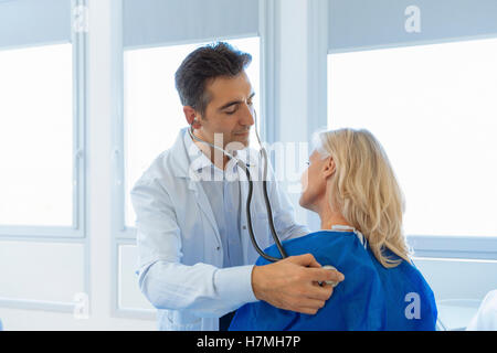 Doctor examining senior patient in hospital Stock Photo