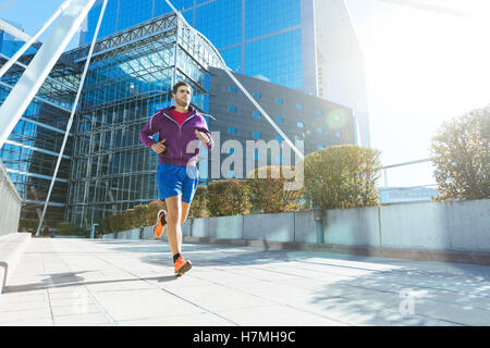 athlete with earphones running in the city Stock Photo
