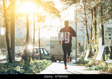 athlete with earphones running in the city Stock Photo