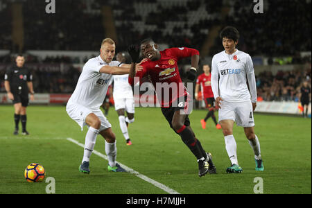 Manchester United's Paul Pogba (centre) in action against Swansea City's Mike van der Hoorn (left) and Ki Sung-yueng during the Premier League match at the Liberty Stadium, Swansea. Stock Photo