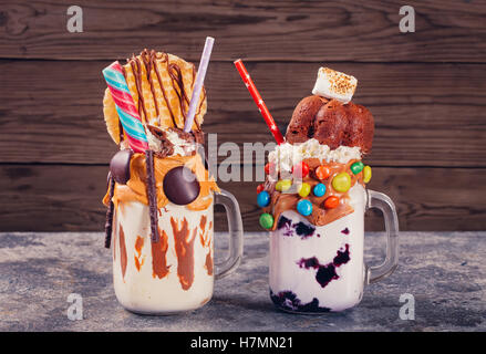Two homemade extreme milkshakes jars on table Stock Photo