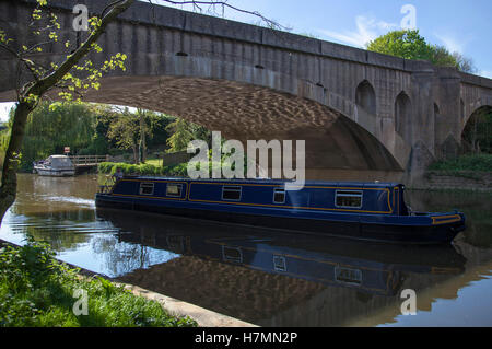 Narrow boat passing under Great North Road on River Nene Wansford Cambridgeshire England UK Stock Photo
