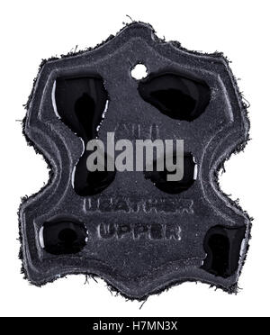 Real leather label in black with water drops on to show water resistance. Isolated on a white background Stock Photo