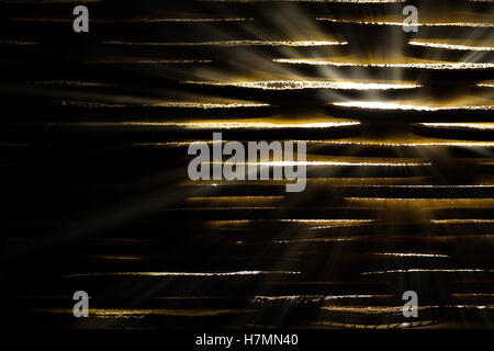 Light glinting though slats with light beams. Dark foreground Stock Photo