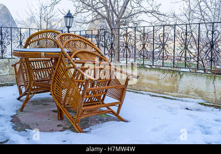 The snowbound terrace with the table and chairs in Goreme, Cappadocia, Turkey. Stock Photo